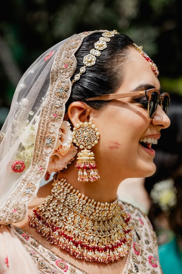Indian bride smiling during a colorful wedding celebration at Savoy Palace, in Madeira Island, in Europe, photographed by Miguel Ponte.