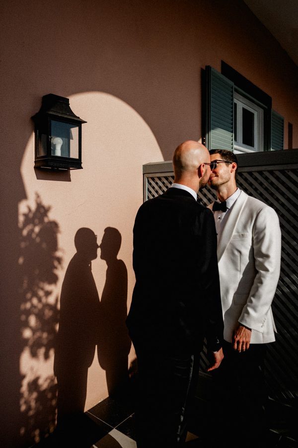 Same-sex wedding couple sharing an intimate editorial portrait at Belmond Reids Palace, Madeira Island, during a destination wedding in Portugal.