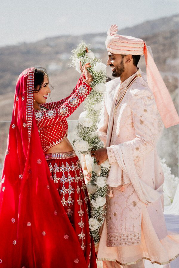 Indian wedding ceremony with traditional garments and floral garlands at the Royal Mikonian in Mykonos, during a multicultural destination wedding in Europe.